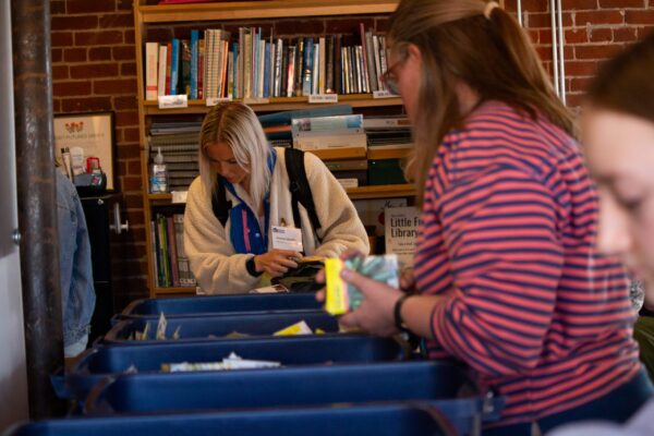 community members picking seeds from bins