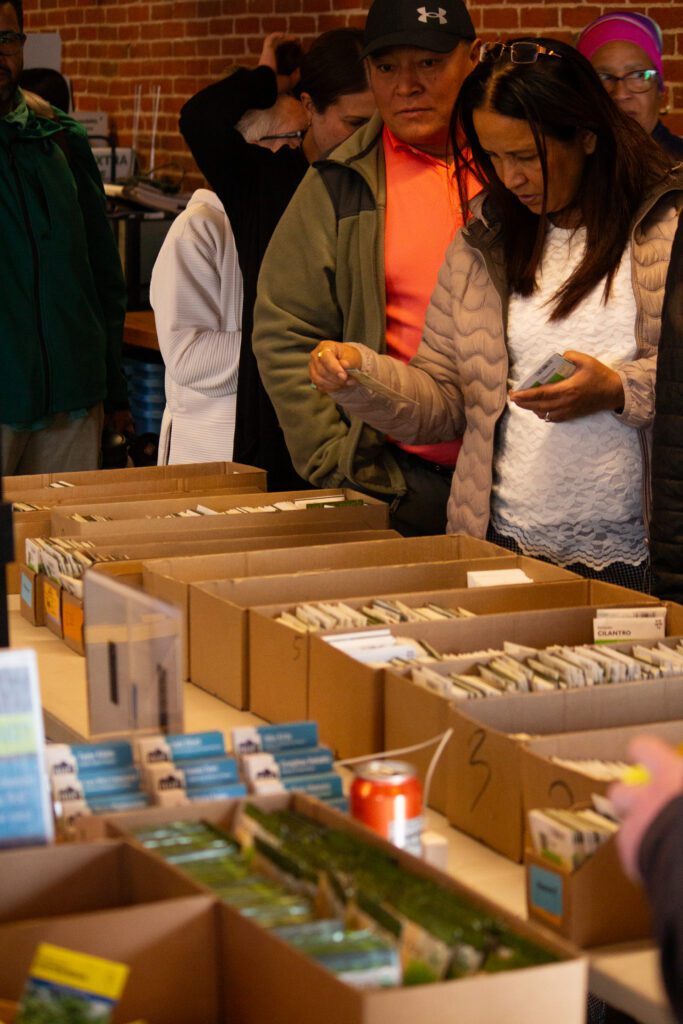 community members picking seeds from bins