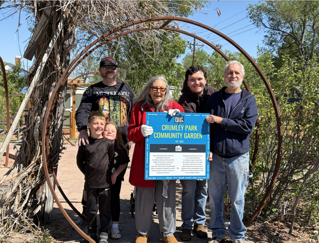april crumley and family holding garden sign