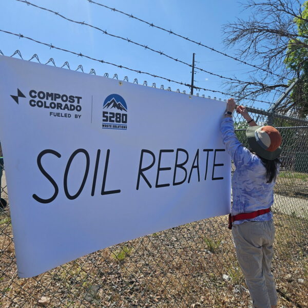 person hanging Compost Colorado Sign soil rebate